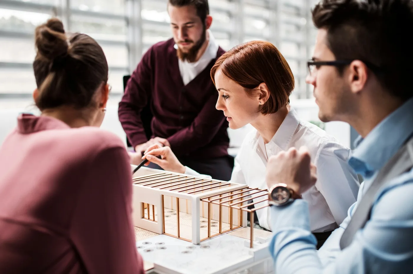 Equipo revisando una maqueta arquitectónica